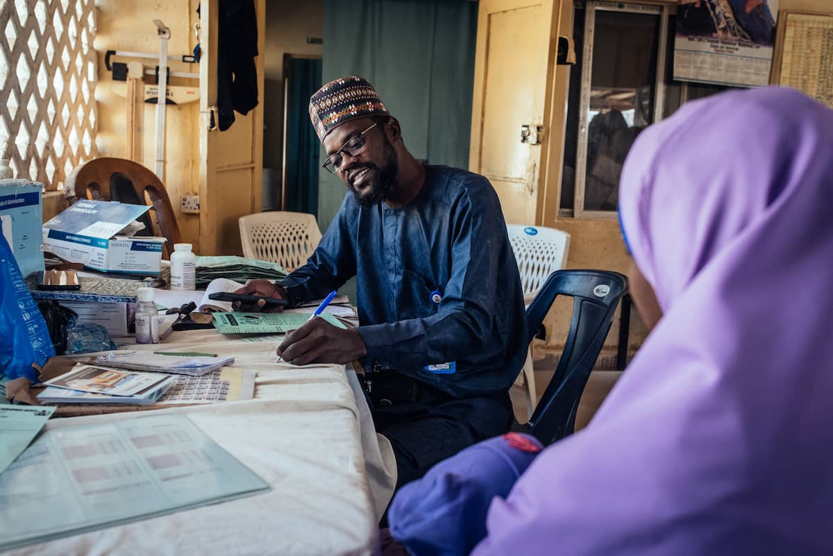 Abubakar atendiendo a una madre con sus hijo.