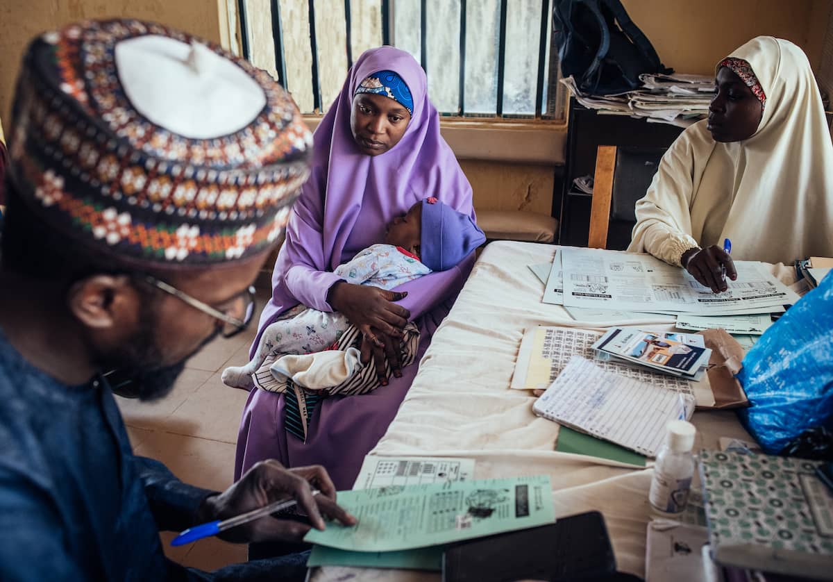 Abubakar rellenando un formulario con una madre.