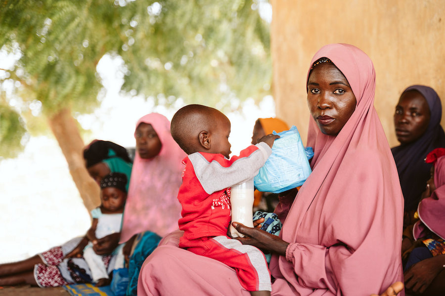 Hauwa llega a la clínica y busca un sitio para sentarse a esperar con las demás madres.